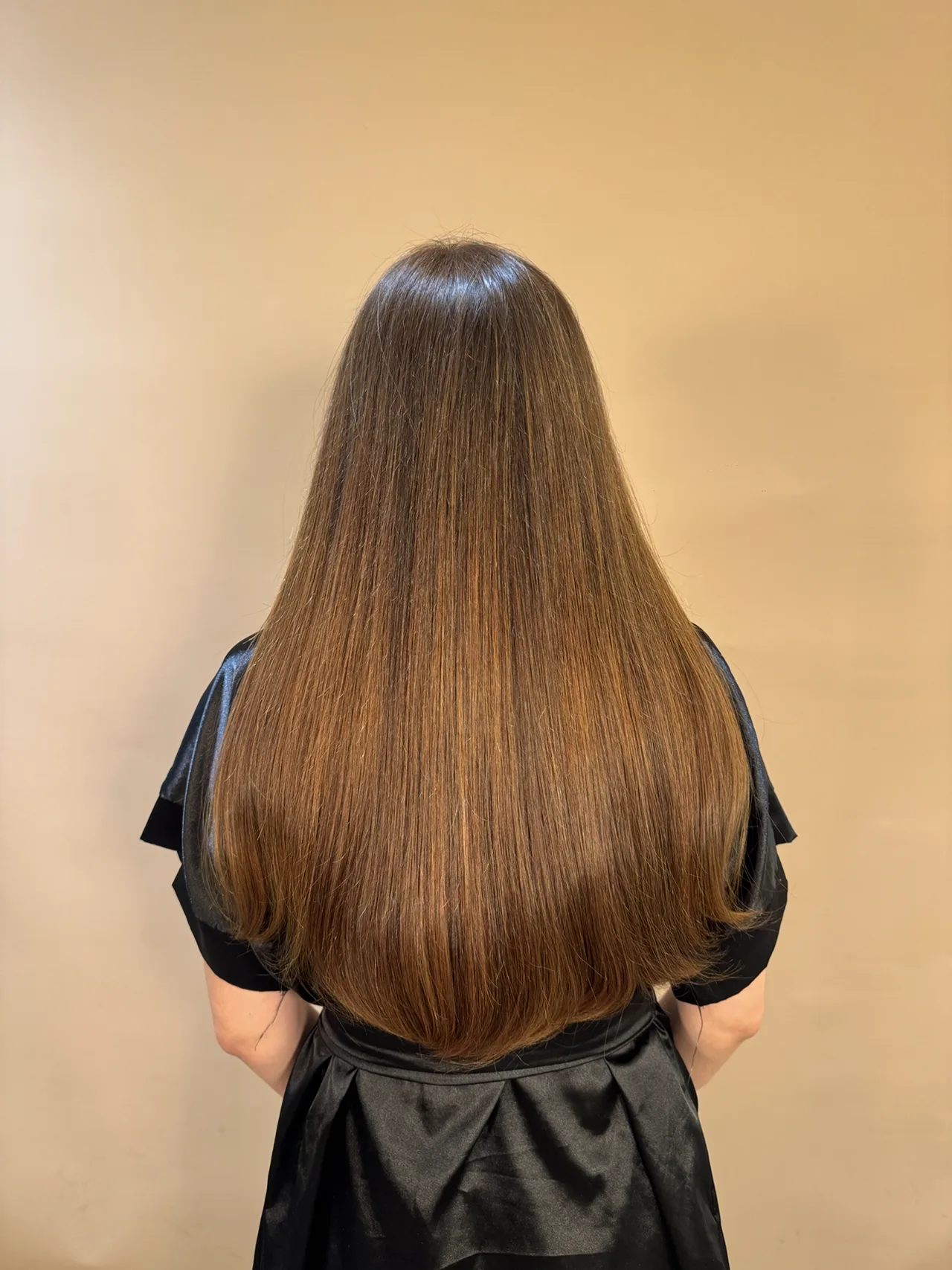 O mesmo cabelo castanho após o Slim Hair, longo e alinhado.