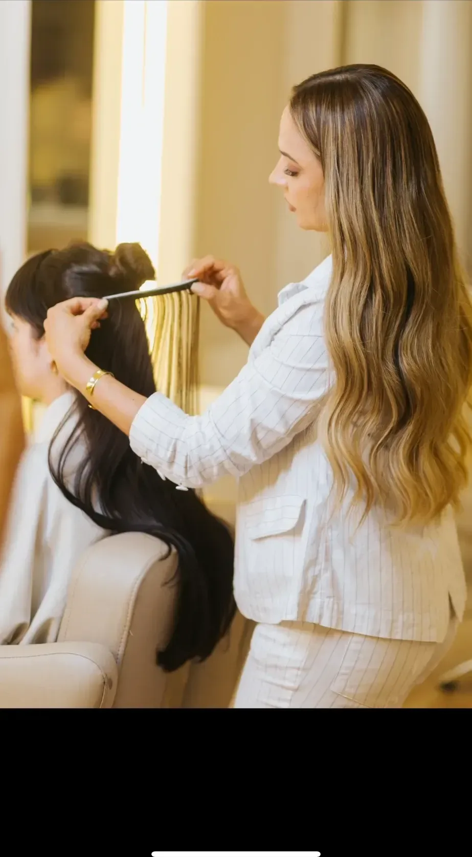 Débora Melo penteando a mecha antes de fixar a faixa no cabelo da cliente.