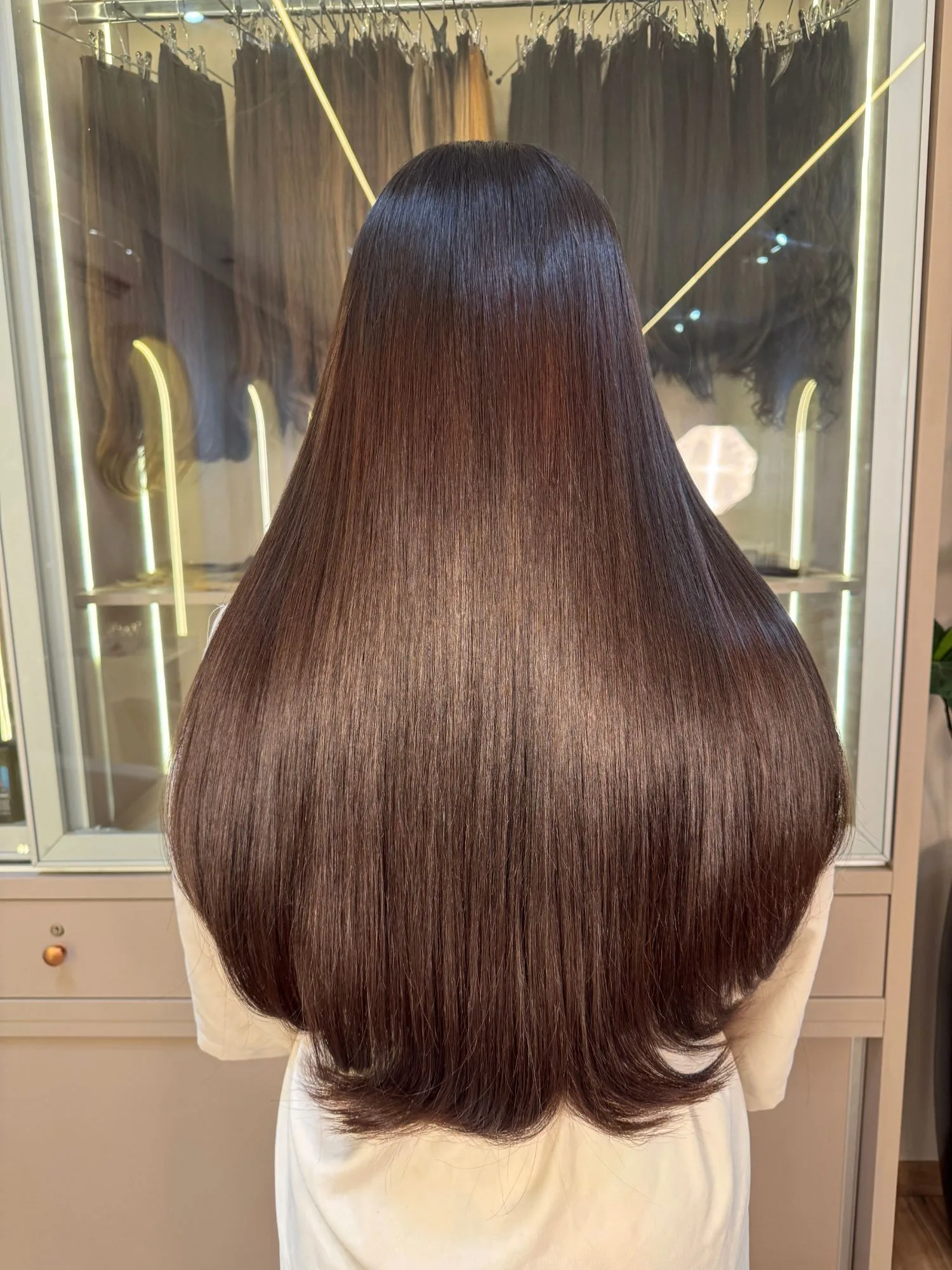 O mesmo cabelo após o Slim Hair, castanho com brilho e pontas viradas.